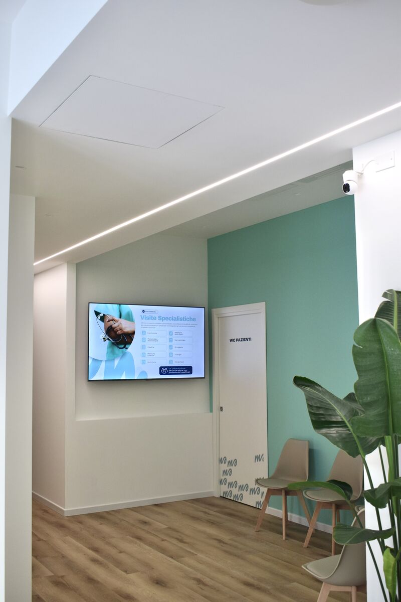 La sala d'attesa con il monitor delle visite specialistiche